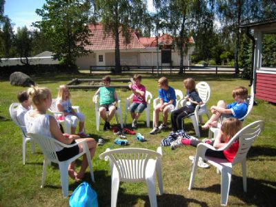 Gänget kör ”Fluffa-fluffa” under sommarens miniläger vid klubbstugan.